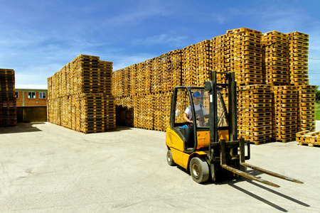 Man operating forklift inside of pallet warehouse の写真素材