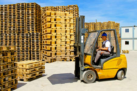 Forklift operator handling euro pallets in warehouse の写真素材