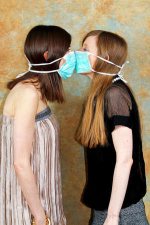 Two girls with protective masks against each other の写真素材