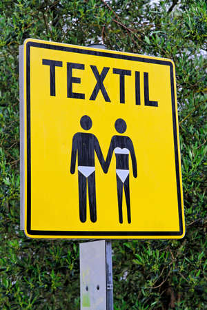 Yellow sign post for textile beach only の写真素材