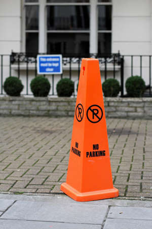 Florescent orange cone with no parking sign の写真素材