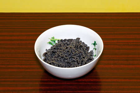 Traditional Italian black Mafaldine pasta in bowl の写真素材