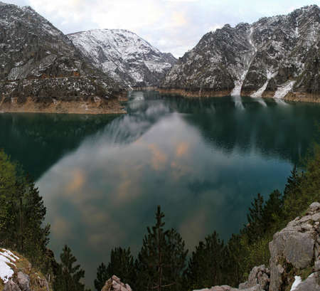 Pivsko Lake and snowy mountains in Montenegroの写真素材