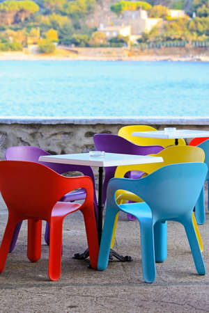 Colourful plastic chairs at sea side balconyの写真素材