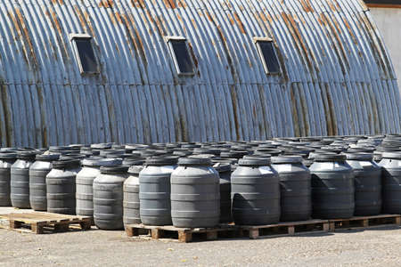 Chemical waste in plastic barrels near warehouseの写真素材