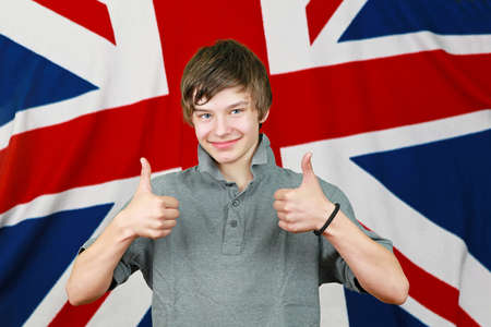 Young British boy with thumbs up in front of Union Jack flagの写真素材