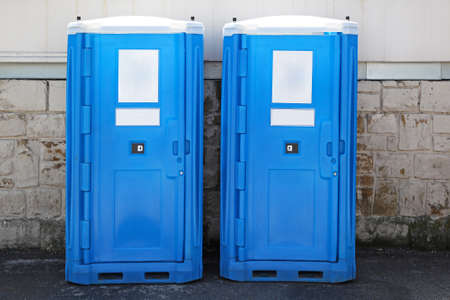 Two blue portable toilet cabins at construction siteの写真素材