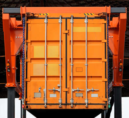 Lifting up orange cargo container in warehouseの写真素材