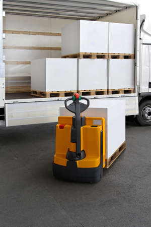 Forklift truck loading pallets of paper in lorryの写真素材