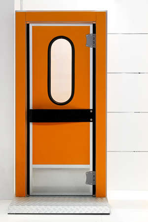 Insulated orange door at industrial fridge reeferの写真素材