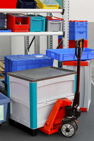Plastic box at pallet truck in storage room