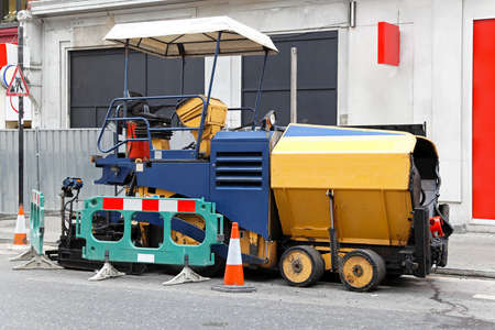 Asphalt surfacing and paving machine at street