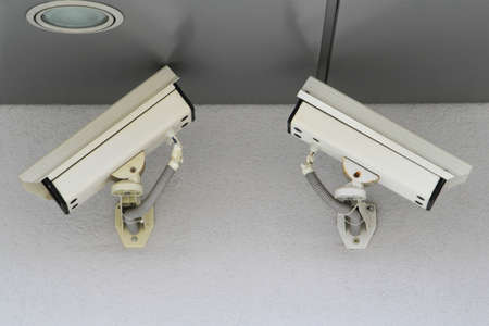 Two old CCTV security cameras at wall