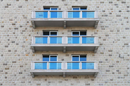 Balconies with blue glass fence at stone buildingの写真素材