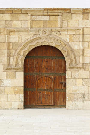 Medieval wooden door with arch entrance in courtyardの写真素材