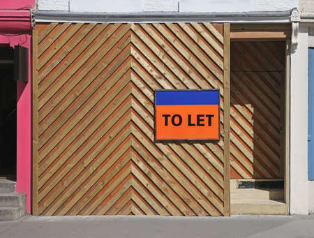 Empty shop with to let sign and wooden barrierの写真素材