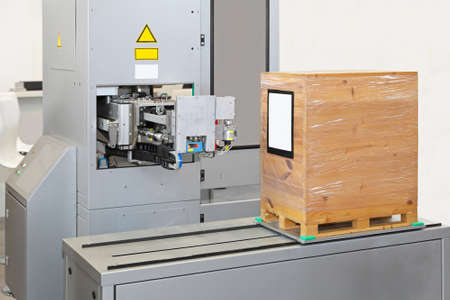 Automated labeling machine at production line in factory