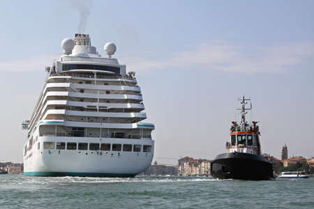 Tugboat pulling cruise ship in Venice Lagoonの写真素材