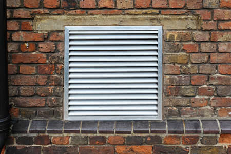 House ventilation grill on brick wall facade