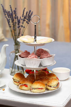 Sandwiches and cakes at coffee tableの写真素材