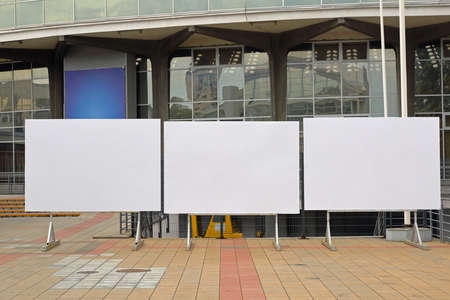 Three empty billboards in front of fair buildingの写真素材
