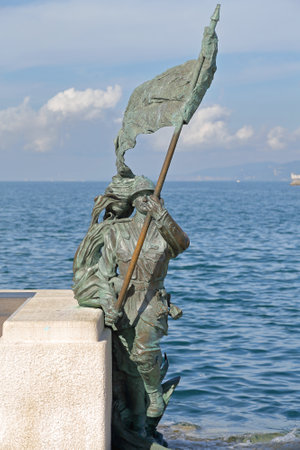 TRIESTE, ITALY - OCTOBER 14: Le Bronze soldier statue with flag in Trieste on OCTOBER 14, 2014. Le Bronze sculpture, one of the symbols of the city, representing solders on the waterfront in Trieste, Italy.のeditorial素材