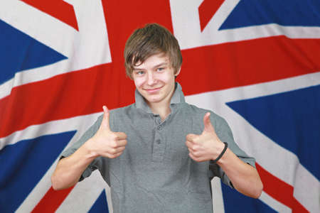Young British Boy Two Thumbs up in Front of Union Jack Flagの写真素材