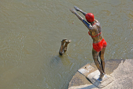 SKOPJE, MACEDONIA - SEPTEMBER 17: The Swimmer Statue in Skopje on SEPTEMBER 17, 2012. Bronze Sculpture of Diving Swimmer Woman in Bikini at Vardar River in Skopje, Macedonia.のeditorial素材