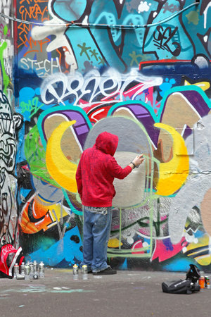 LONDON, UNITED KINGDOM - JANUARY 26: Hooded Graffiti Artist in London on JANUARY 26, 2013. Young Vandal Spraying Walls With Paint in London, United Kingdom.のeditorial素材
