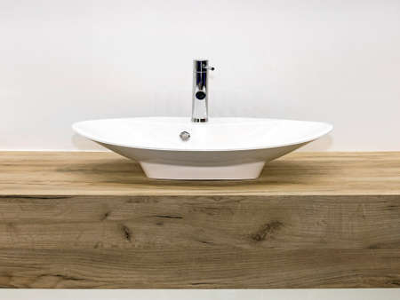 Ceramic Wash Basin at Wooden Counter in Contemporary Bathroomの写真素材