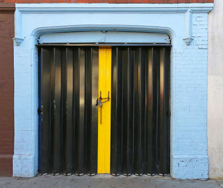 Closed Black Accordion Doors Locked With Chain and Padlockの写真素材