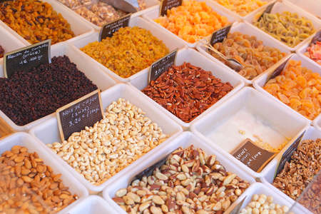 Dried Fruits and Nuts in Plastic Tubs at Marketの写真素材