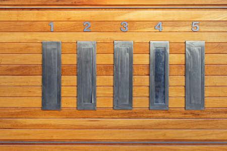 Letterbox Slots in Building Interior at Wooden Wallの写真素材
