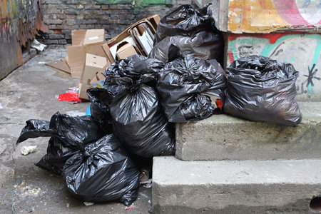 Black Trash Bags Litter Garbage in Alleyのeditorial素材