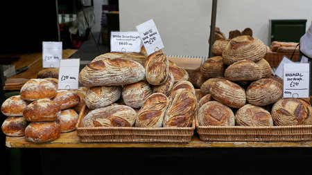Loaves of Artisan Bread at Table in Bakery Shopの写真素材