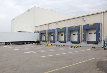 White Semi Truck Trailer at Warehouse Loading Ramp
