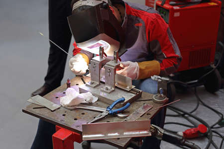 Welder Worker at Table Work Bench in Factory Production