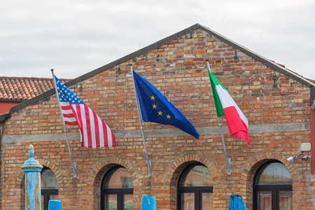 Usa EU and Italian Flags at Bricks Buildingの写真素材