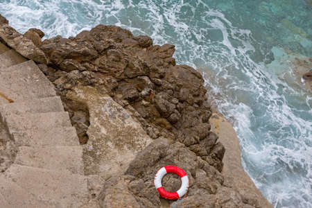 Lifesaver Buoy Ring at Rough Sea Coast Stairsの写真素材