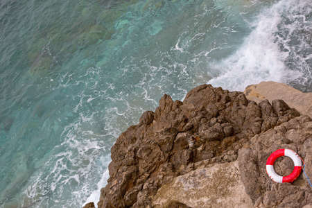 Lifesaver Buoy Ring at Rocky Sea Coastの写真素材