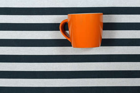 Big Orange Ceramic Mug at Striped Backgroundの写真素材