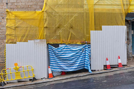 Construction Site Barrier and Scaffolding at Steep Slope Streetの写真素材