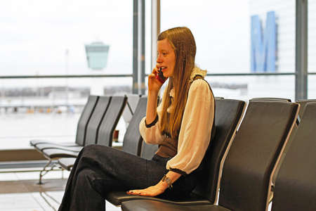 Young Woman Holding Cell Phone at Airport