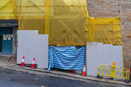 Construction Site Barrier and Scaffolding at Steep Slope Street