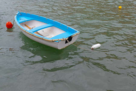 Small Plastic Dinghy Boat Moored at Sea