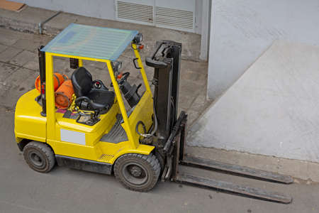 Gas Powered Yellow Forklift Truck in Front of Building