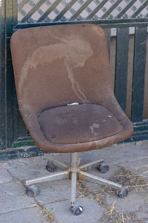 Old Brown Beaten Up Office Chair Outsideの写真素材