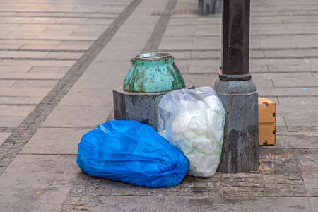 Garbage Bags Litter Arround Trash Can at City Street