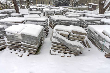 Pallets With Pavement Tiles Covered With Snow Construction Site at Winterの写真素材