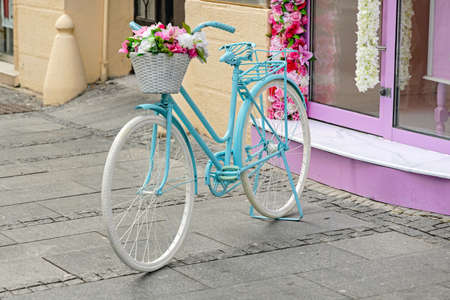 Light Blue Womens Bicycle Parket at Street With Flowers Basketの写真素材